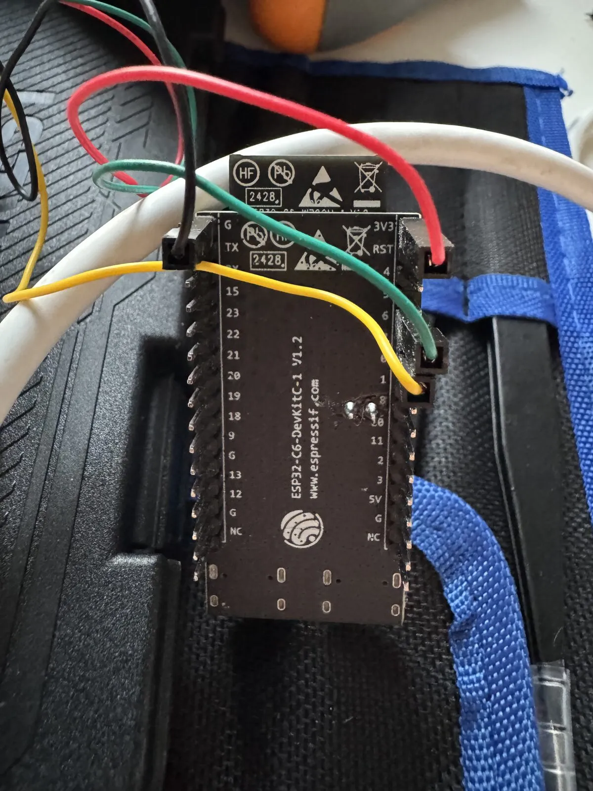 The underside of the ESP32-C6 board — two solder pins sit in the middle, where a support rail would have collided