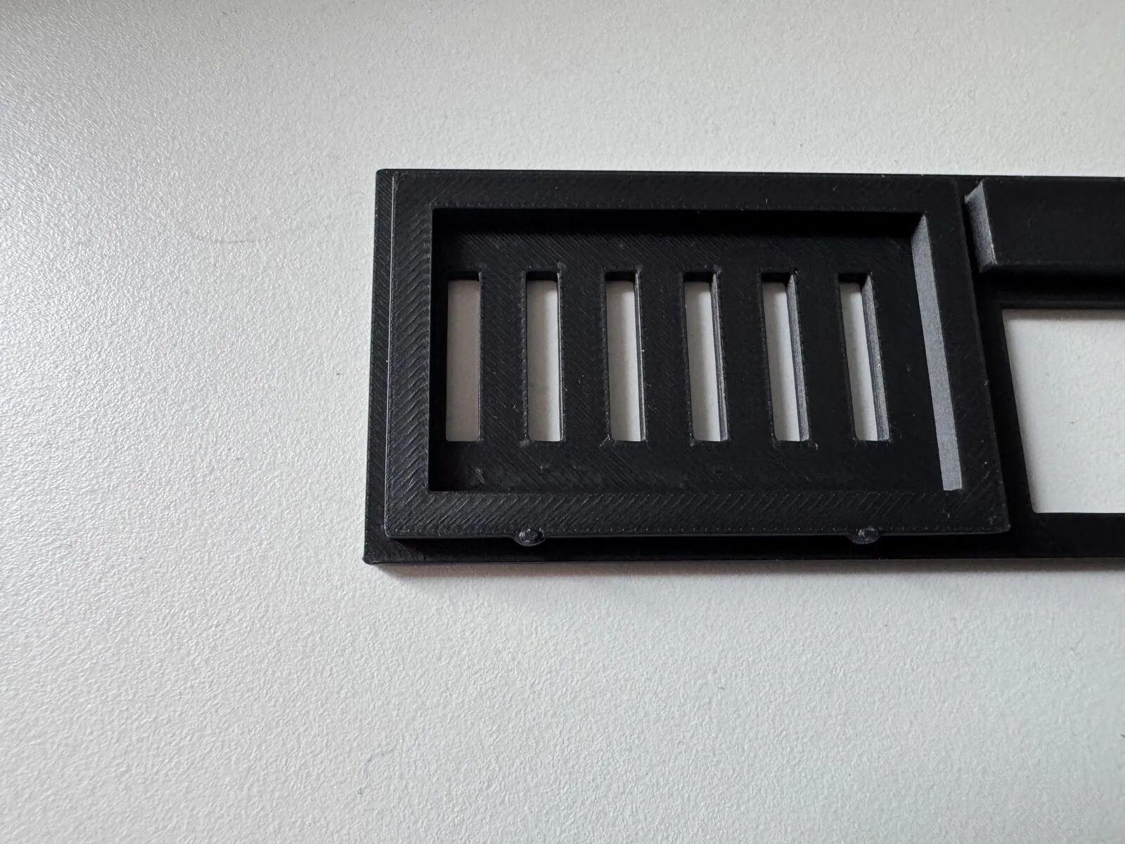 Close-up of the lid from below: the surrounding lip with two of the ball-shaped snap bumps, and the grille that sits above the board